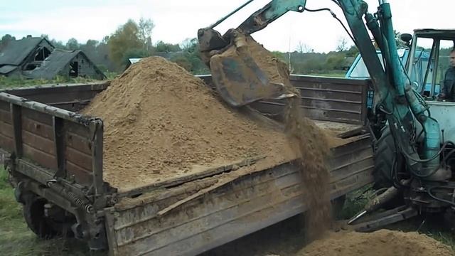 экскаватор ЮМЗ копает песок