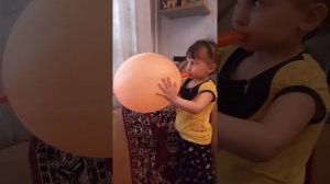 Кира надувает шарик