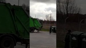Мусоровоз загружает мусор