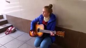Девушка красиво играет на гитаре и поет песню