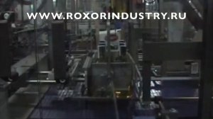 Упаковка стеклянных бутылок с алкоголем в картонную упаковку.