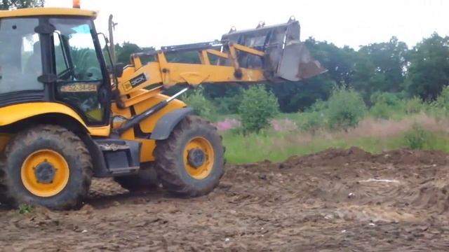 Работа планировщика JCB 3CX на отсыпке земельного участка в Калининграде