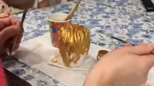 Красим скульптуру Льва золотой краской.