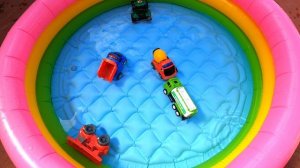 Игрушечные машинки купаются в бассейне. Toy cars in the swimming pool.