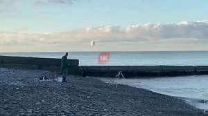 На видео рыбак, на фоне работы ПВО сегодня в Сочи.