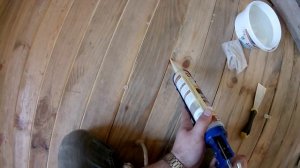 Заделка щелей между половыми досками при помощи герметика по дереву.