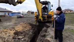 Копаем траншею, подводим воду  под  газовой  трубой к участку .