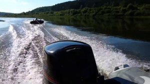 На надувном матрасе за лодкой