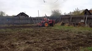 Маленький трактор пашет огород