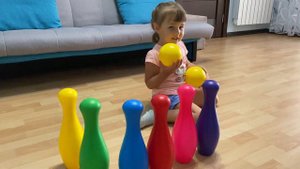 Учим цвета играя в кегли. Илона играет с кеглями.