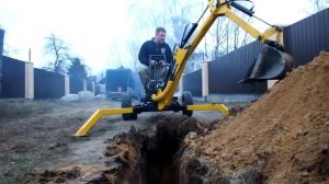 мини экскаватор копает траншею