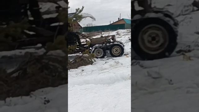 Мотоблок на гусеницах по глубокому сырому снегу в затяжную гору