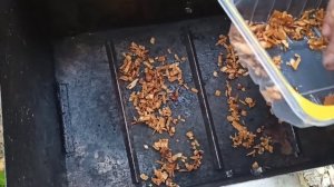 Копченые свиные ребра и мясо в коптильне на мангале