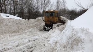 Бульдозер толкает снег