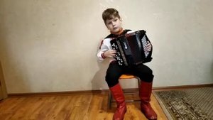 Мальчик играет на баяне: Отговорила роща золотая.