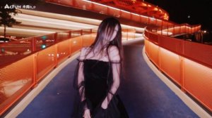 Девушка танцует в черном платье, в черных колготках и туфлях на шпильке.