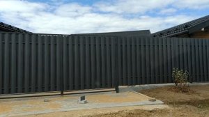 Забор.  Вместо фундамента уложены бордюрные блоки.