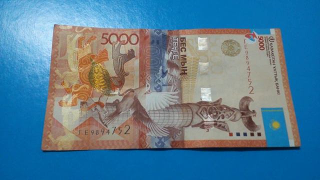 БАНКНОТА 5000 ТЕНГЕ № серии ГЕ9894752 на синей поверхности 20-го Апреля - ДЕНЕЖНЫЙ ПОТОК смотреть онлайн