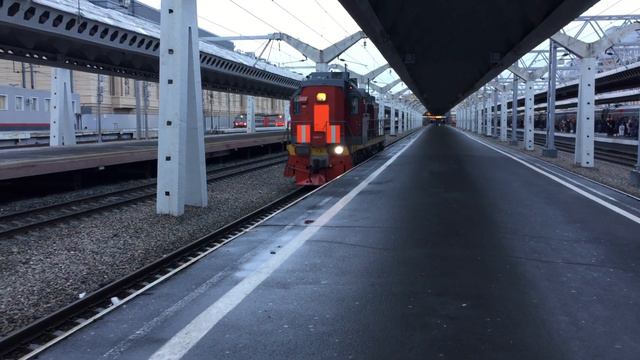 ТЭМ18В-020. Выезжает из под пассажирского поезда и ЧС2Т-?. На заднем плане.