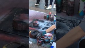 Уличный художник рисует картину .