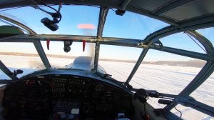 Зимний взлет самолета Ан-2 на лыжах. Полет в ясном небе без облаков.