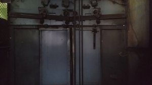 Вид на сетчатую шахту лифта с этажными переключателями.