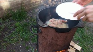 Настоящий цыпленок табака в казане на костре.