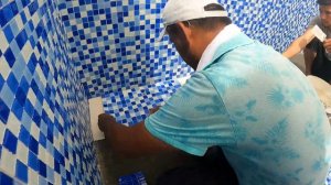 Процесс укладки стеклянной мозаики в  басейне.