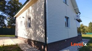 Отделка фасада загородного дома виниловым сайдингом.