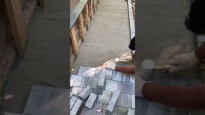 Мощение отмостки вокруг дома тротуарной плиткой.