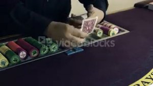 dealer shuffling and dealing cards onto table