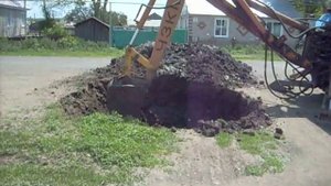 экскаватор роет яму..