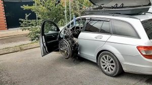 Погрузка инвалидной коляски на крышу машины.