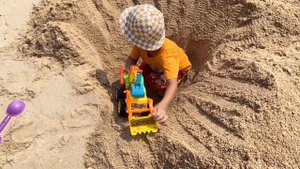 Малыш и сонный папа играют в трактор экскаватор и динозавра на пляже