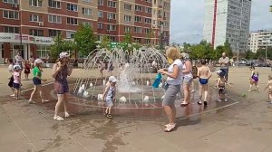 Дети купаются в фонтане