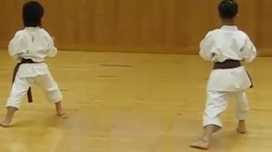 Мальчик и девочка (6 и 7 лет) сдают экзамен на черный пояс по карате