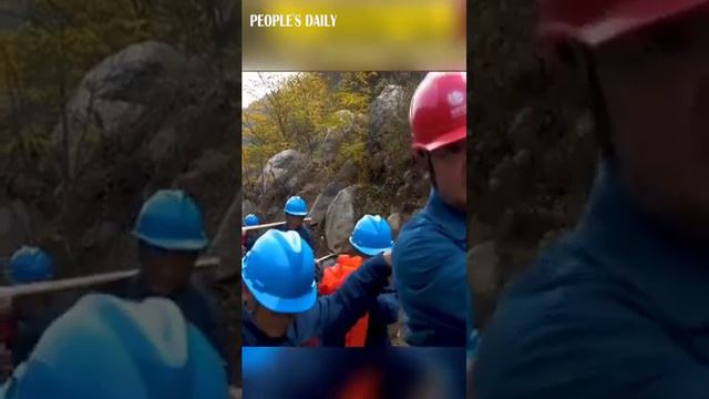 Hundreds of workers formed a line to carry a 3.8-ton cable up Mount Tai in E China