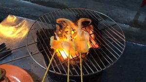 Вьетнамский стритфуд, щупальцы кальмара на гриле. Street food in Vietnam, squid tentacles.