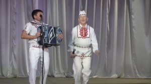 Веселый дедушка-фанат зажигательно танцует.