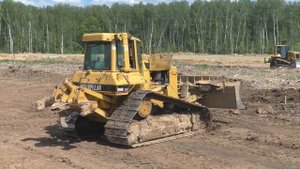 Бульдозер Cat D6N LGP снимает плодородный слой