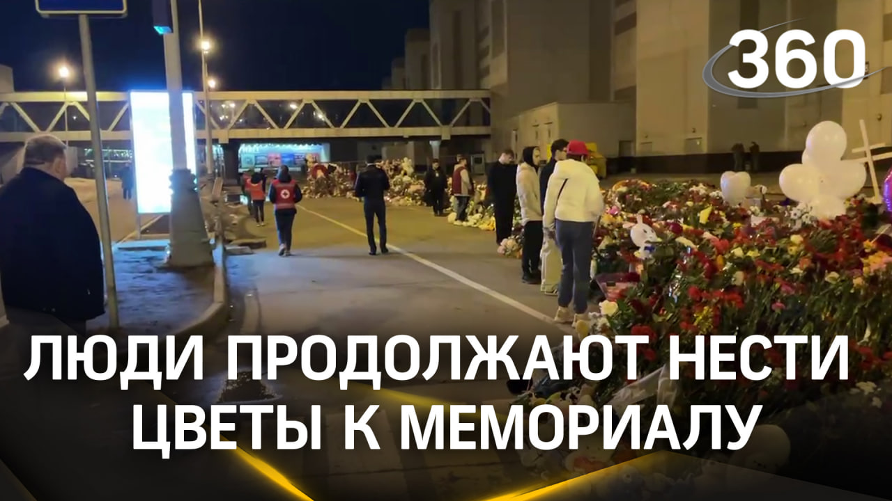 Люди, несмотря на ночь, продолжают нести цветы к стихийному мемориалу у «Крокуса»