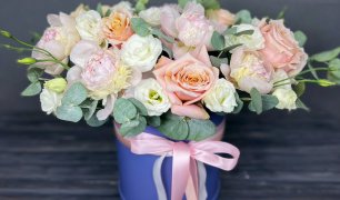 Пионы, розовые и белые розы с веточками эвкалипта в шляпной коробке. Красивый букет цветов в коробке
