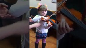 Преподаватель музшколы учит девочку как правильно играть на скрипке