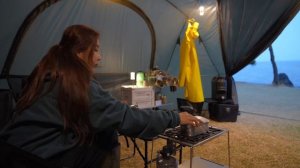 Промокшая девушка отдыхает в большой палатке под дождём