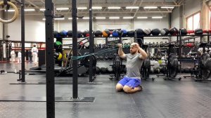 Тяга резины к лицу + вращение плеча наружу сидя на полу с паузой в конце