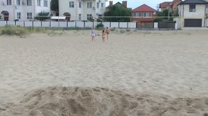 Дети веселятся в огромной яме на морском пляже