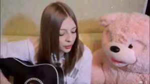 Девушка красиво играет на гитаре и поет песню Холодный ветер с дождем