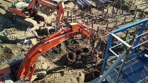 Строительная площадка Экскаватор бурит песчаный грунт бурение отверстий под сваи 2022. Лето июню.