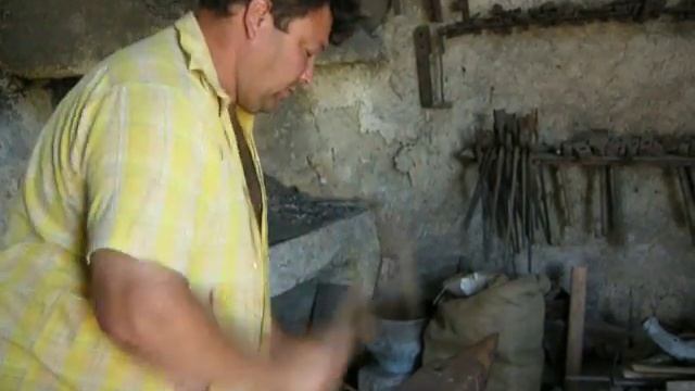 Кузнец Михаил раскаляет металл ударом молотка