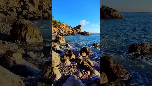 Тихо плещутся волны о камни на диком пляже. Крым.